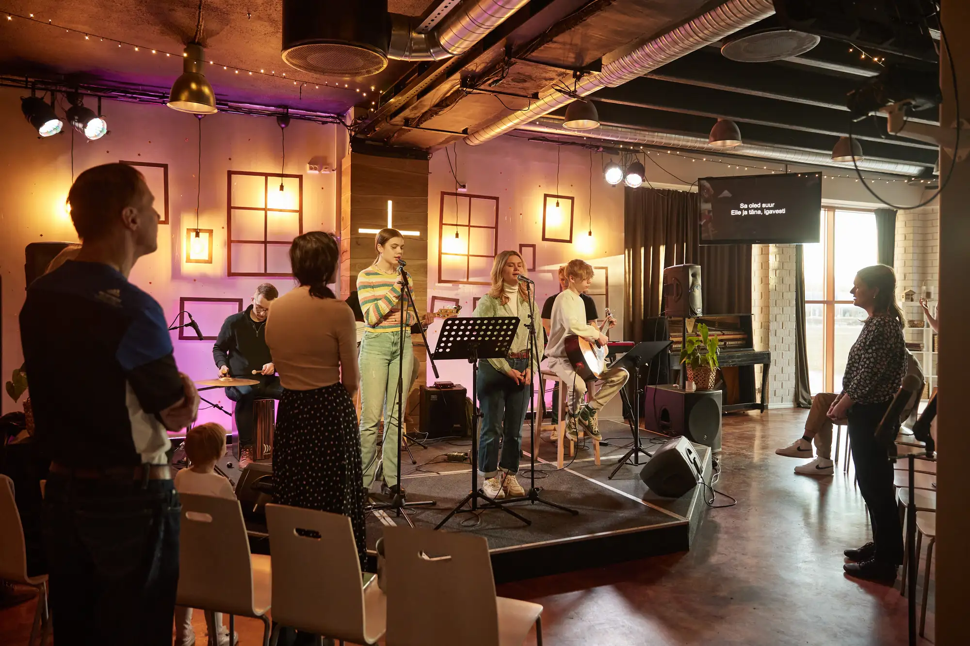 The worship team on stage, the hall in violet light